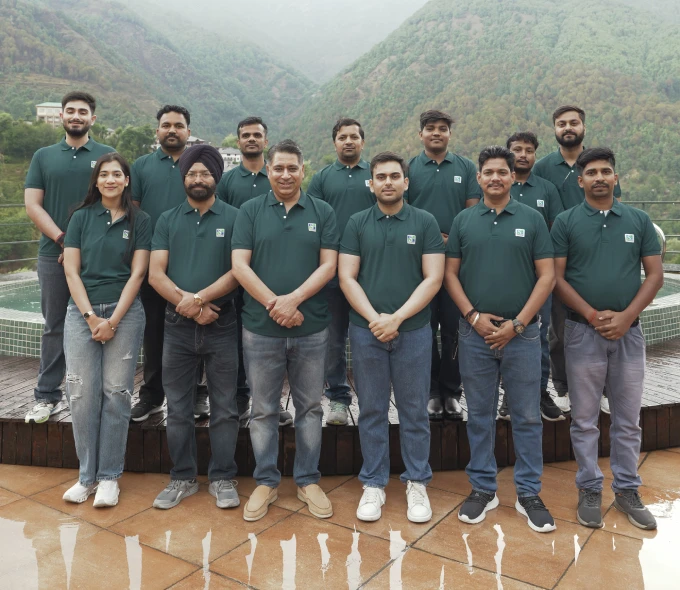 The Square Corporation team standing together wearing matching green polo shirts.